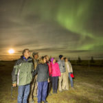 Guests and northern lights at Nanuk Polar Bear Lodge.