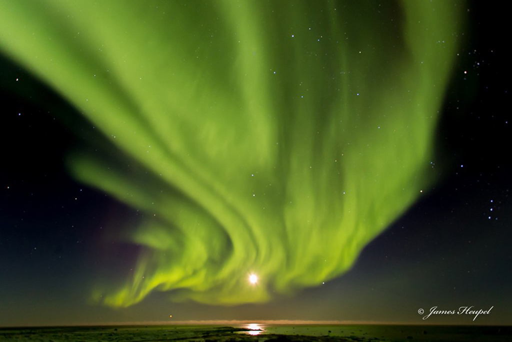 Northern lights draped over full moon on Hudson Bay. The Story Behind the Photo.