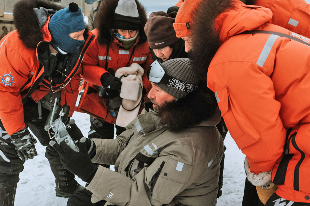 Jad Davenport looking at photos with guests at Nanuk Polar Bear Lodge. Hannah Rheaume photo.