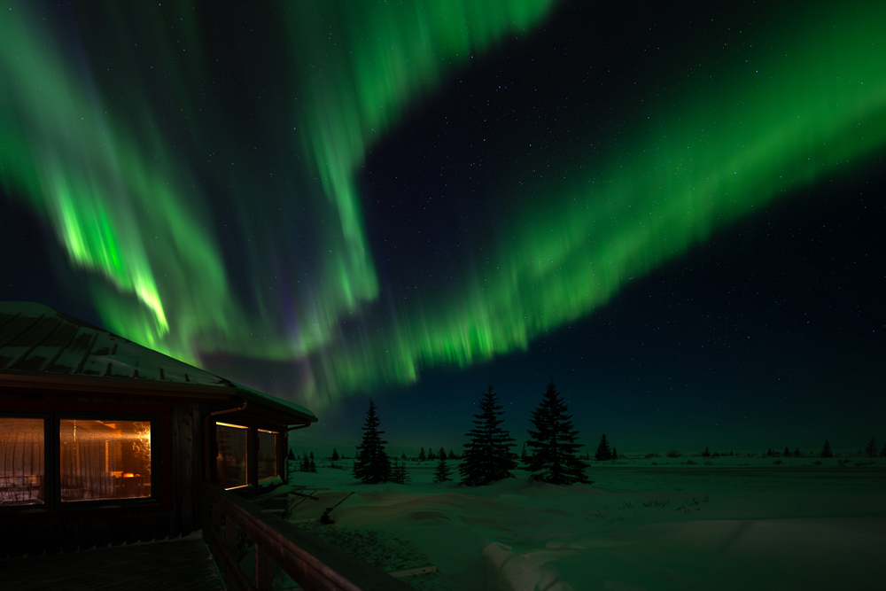 Northern lights dancing over Nanuk Polar Bear Lodge. Fabienne Jansen / ArcticWild.net photo.