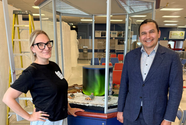 Churchill Wild diorama creator Jen Arnold and Manitoba Premier Wab Kinew in front of Jen's new creation at the Churchill airport.